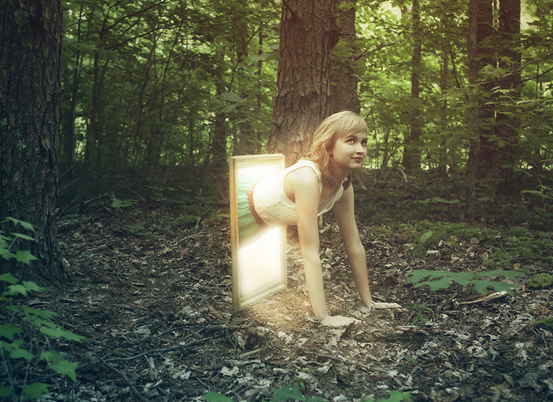 A woman climbs out of a picture frame into a forest