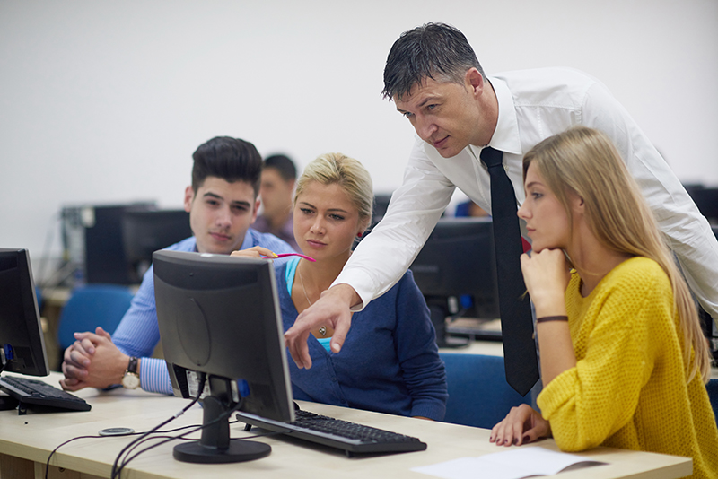 group of students with teacher in computer lab classroom