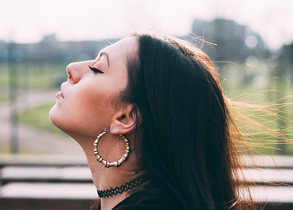 Portrait of young a woman feeling free outdoor in the city, eyes closed - freedom, relaxing, peaceful concept