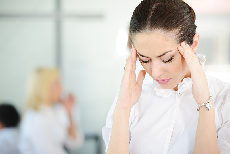 Woman with stress and worries at work in a office