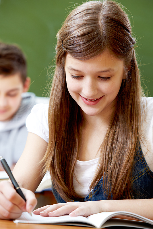 Smiling girl doing her school work