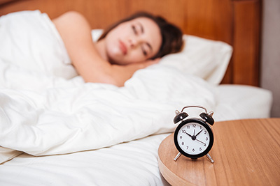 Woman sleeping next to alarm clock