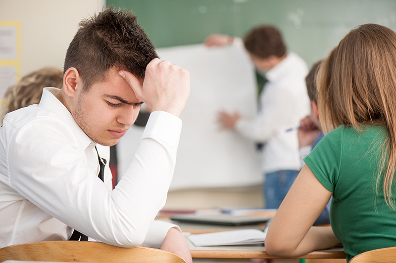 Sad looking boy sitting in a classroom